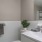 Bath with single vanity and large mirror with plenty of light.