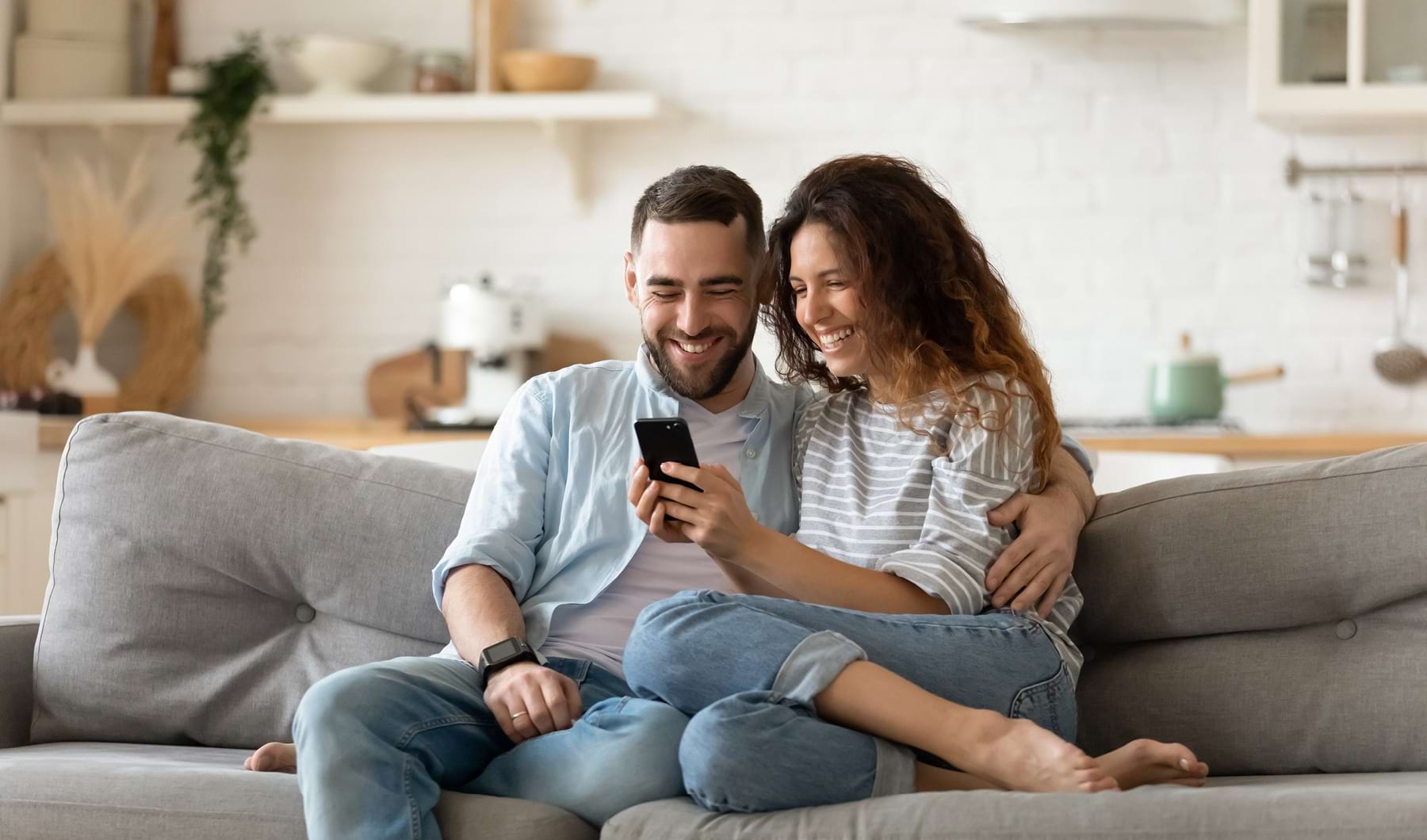Lifestyle at Highland Manor Apartments Man and woman on couch looking at phone
